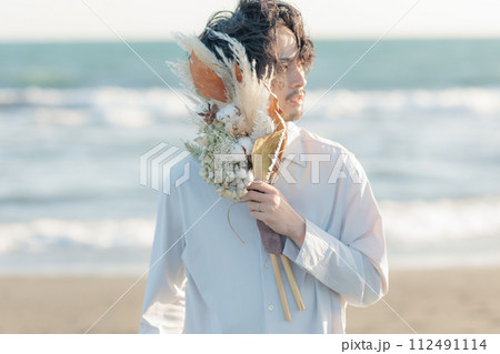 海辺に佇む白シャツを着た30代男性 海辺に佇む白シャツを着た30代男性 112491114