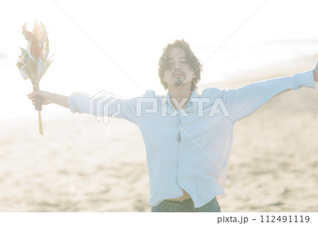 海辺に佇む白シャツを着た30代男性 112491119