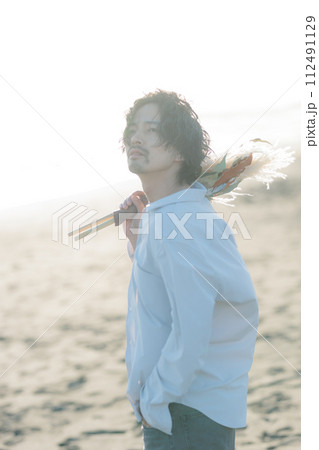 海辺に佇む白シャツを着た30代男性 112491129