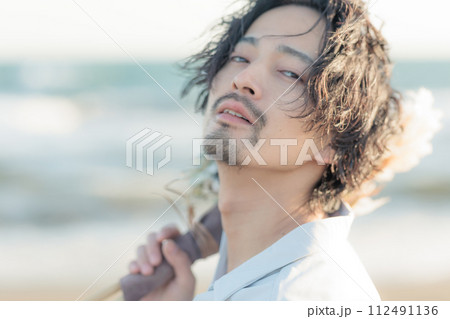 海辺に佇む白シャツを着た30代男性 海辺に佇む白シャツを着た30代男性 112491136
