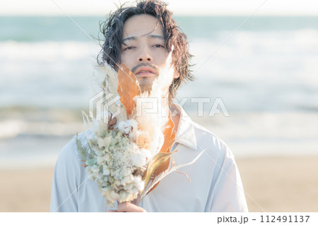 海辺に佇む白シャツを着た30代男性 112491137