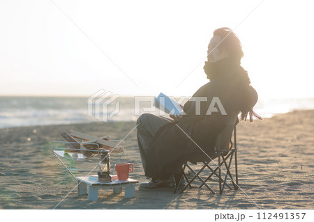 海辺て焚き火をする30代男性 112491357