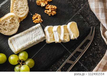 Close-up of cheese and grapes on slate 112491554