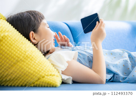 スマホで動画を見る女の子 112493370