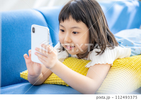 スマホを見る小学生 112493375