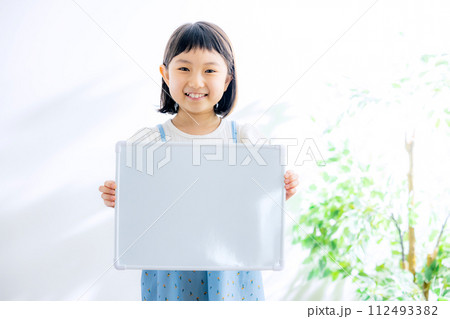 ホワイトボードを持つ小学生の女の子 112493382