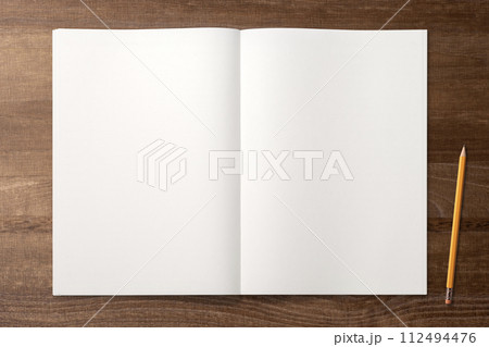 木のテーブルの上にあるノートと鉛筆 112494476