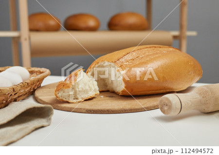 Whole grain bread on bakery kitchen table with fresh baked pastry on shelves on background Whole grain bread on bakery kitchen table with fresh baked pastry on shelves on background 112494572