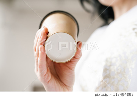 Close up mockup of the bottom of a paper cup in the hands of a woman Close up mockup of the bottom of a paper cup in the hands of a woman 112494895