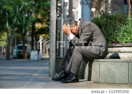 シニア男性　スーツ　座る　頭を抱える 112495269