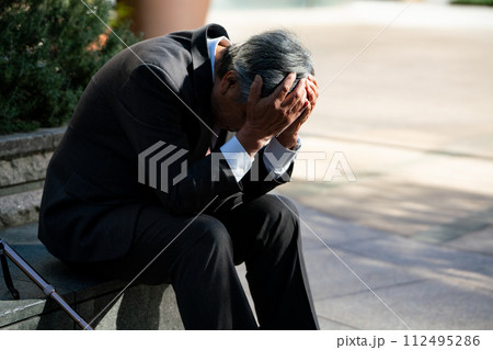 シニア男性　スーツ　座る　頭を抱える 112495286