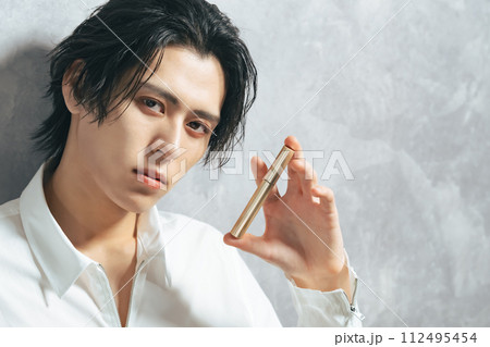 コスメを持った男性　メンズコスメ　男性用化粧品 112495454