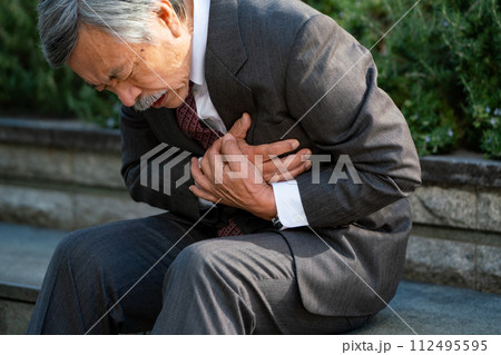 シニア男性　スーツ　心臓発作　座る 112495595