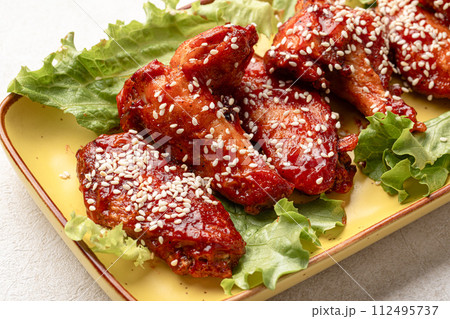 Cooked chicken wings in sauce and sesame seeds Cooked chicken wings in sauce and sesame seeds 112495737