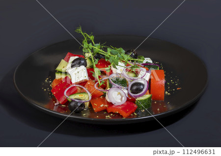 Salad with olives and cucumbers, tomatoes, cheese and sauce. Boiled egg. 112496631