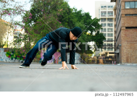 Young handsome male dancer in stylish clothes showing hip hop performance on the street Young handsome male dancer in stylish clothes showing hip hop performance on the street 112497965