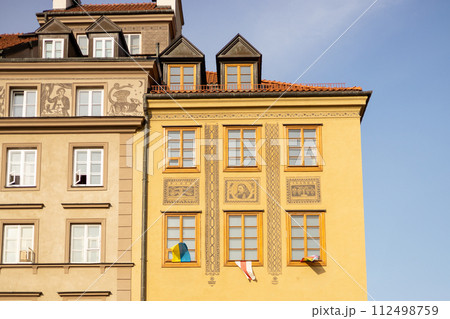 Colorful historic houses in the Old Town of Warsaw city, Poland. Traditional architecture with flags, travel postcard 112498759