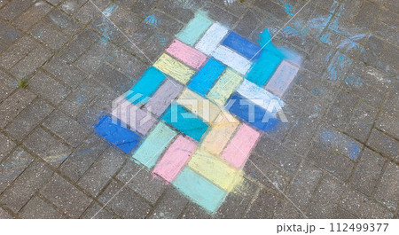 Children's drawing with colored crayons on paving slabs. The concept of the Children's Day holiday Children's drawing with colored crayons on paving slabs. The concept of the Children's Day holiday 112499377
