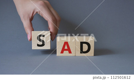 Sad symbol. Wooden cubes with words Sad. Businessman hand. Beautiful grey background. Business and Sad concept. Copy space. 112501612