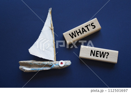 What is new symbol. Concept word What is new on wooden blocks. Beautiful deep blue background with boat. Business and What is new concept. Copy space 112501697