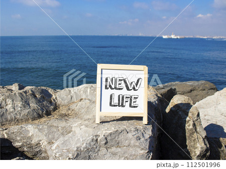 New life symbol. Concept words New life on white chalk background. Beautiful sea background. Business and New life concept. Copy space. 112501996