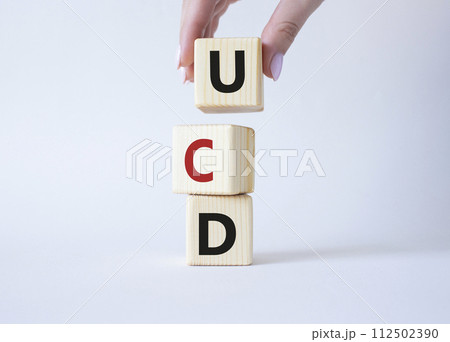 UCD - User Centered Design. Wooden cubes with word UCD. Businessman hand. Beautiful white background. Business and User Centered Design concept. Copy space. UCD - User Centered Design. Wooden cubes with word UCD. Businessman hand. Beautiful white background. Business and User Centered Design concept. Copy space. 112502390