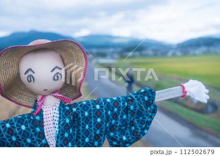 稲刈りの終わった田圃に残された案山子 112502679