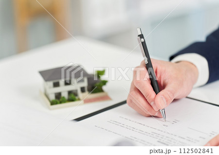 不動産の契約書にサインをするビジネスマン 112502841