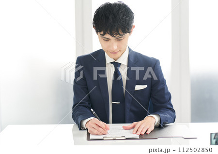 育児休暇申請書に記入するビジネスマン 112502850