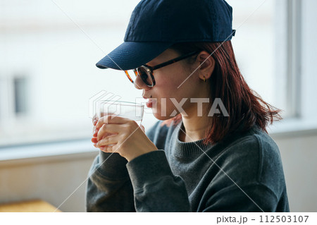 グラスを持つ若い女性 112503107