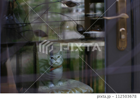 窓辺で見つめる猫の置物 112503678