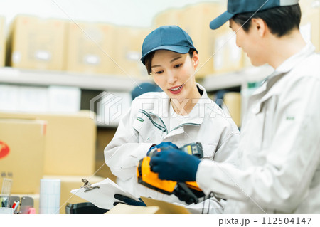 バックヤードで重さを測る若い作業員 112504147