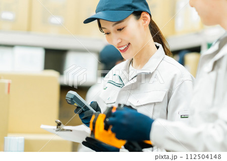 バックヤードで重さを測る若い作業員 バックヤードで重さを測る若い作業員 112504148