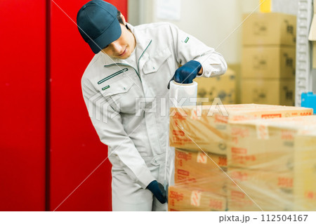 出荷前にラッピングをする若い作業員 出荷前にラッピングをする若い作業員 112504167