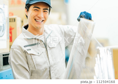出荷前にラッピングをする若い作業員 112504168