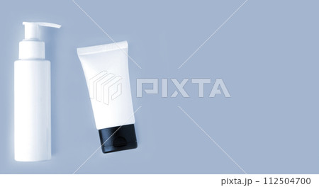 White bottle and tube of cosmetic products background 112504700