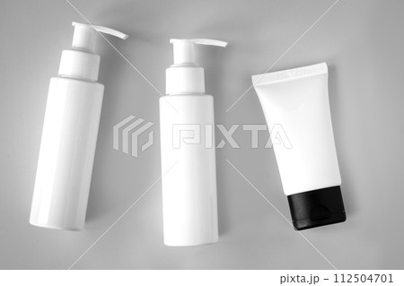 White bottles and tube of cosmetic products background 112504701