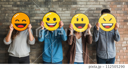 Healthy workplace culture concept. A group of diverse people holding happy emoticons. Teamwork 112505290