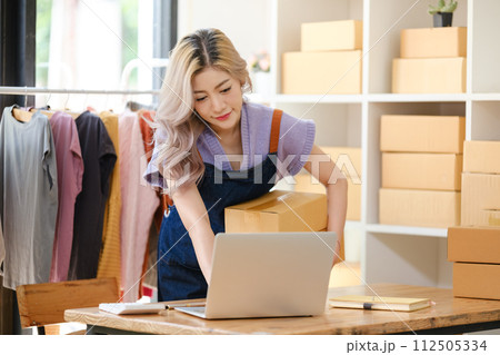 Young Asian female woman starting SME small businesses owners to be entrepreneurs, business woman smile and use tablet computer notebook for sell product online making marketing internet online 112505334
