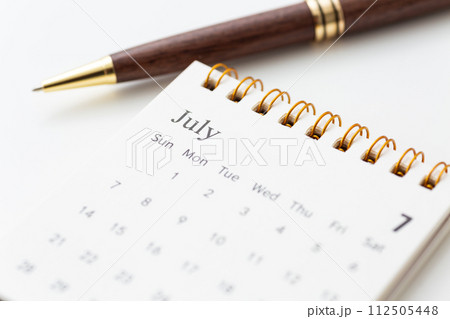 7月のカレンダーとボールペン 112505448