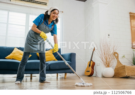 Asian teenager lively cleanup, maid listens dances sings using headphones. Joyful occupation with music excitement. Modern cleaning tech-driven fun. Give me melody, Happy and Fun During Cleaning Asian teenager lively cleanup, maid listens dances sings using headphones. Joyful occupation with music excitement. Modern cleaning tech-driven fun. Give me melody, Happy and Fun During Cleaning 112506766