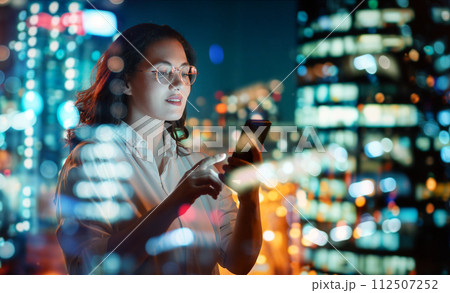 businesswoman using phone near window 112507252
