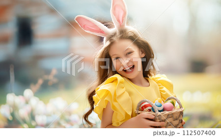 child with painting eggs outdoors 112507400