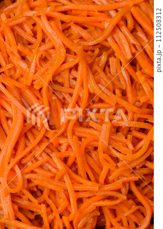 Tasty spicy Korean carrot with spices and herbs on a dark concrete background Tasty spicy Korean carrot with spices and herbs on a dark concrete background 112508312