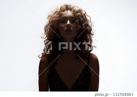 curly Hair Girl silhouette. Beautiful young Woman in white studio 112508861