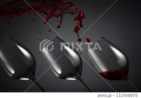 Empty wine glasses and red wine splashes on a dark background. Empty wine glasses and red wine splashes on a dark background. 112508878