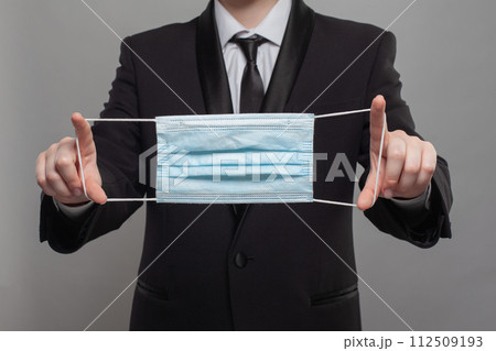 Business person holding medical protective mask to health protection and prevention from allergy Business person holding medical protective mask to health protection and prevention from allergy 112509193