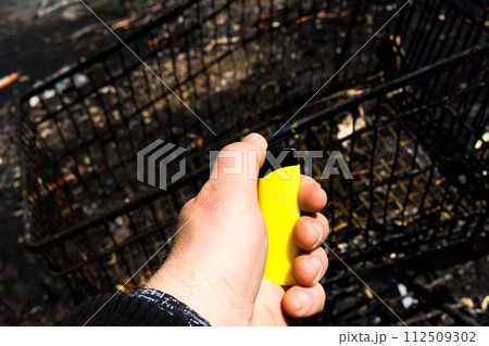 Burnt metal lighter in ashes. Consequences of the fire. Close-up. 112509302