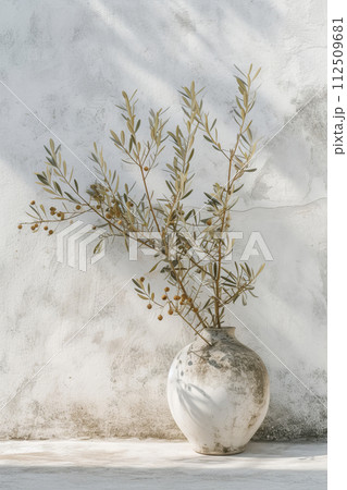 White concrete vase with olive tree branch White concrete vase with olive tree branch 112509681