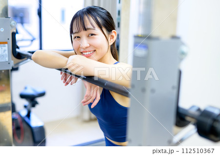 ジムで体を鍛える女性　ポートレート　休憩する筋トレ女子　ワークアウト　 112510367